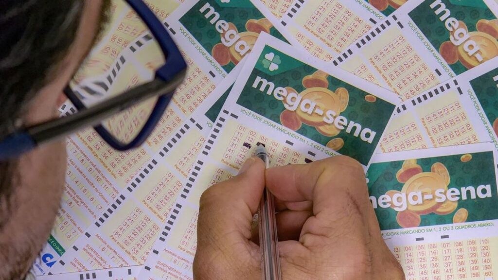 Mão marcando números da Mega-Sena