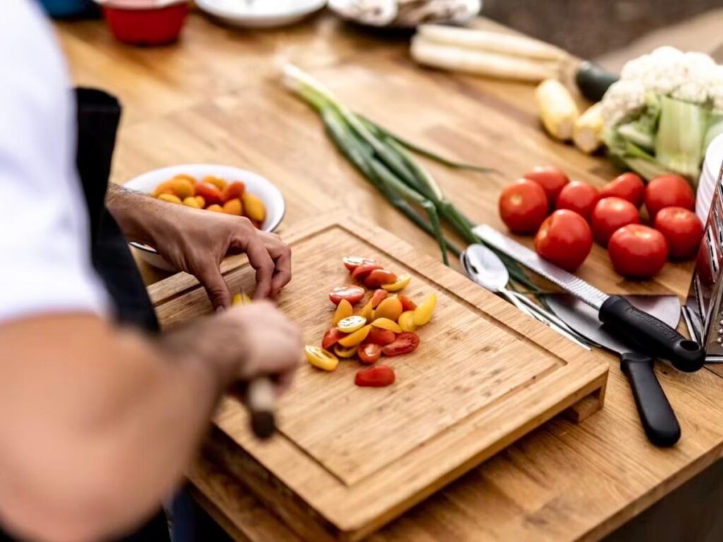 Imagem colorida de homem cortando legumes