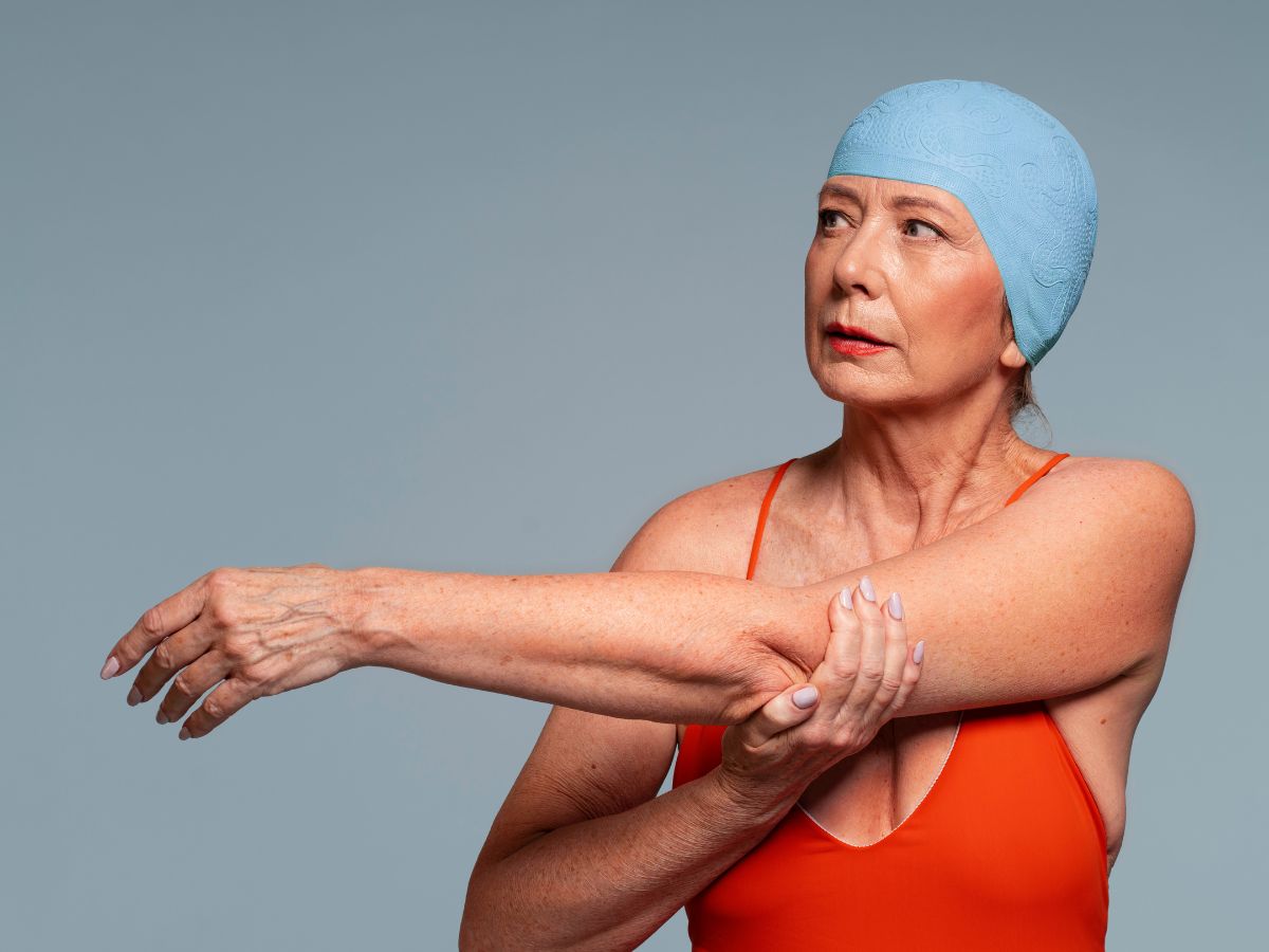 Idosa com trajes de banho se alongando para natação