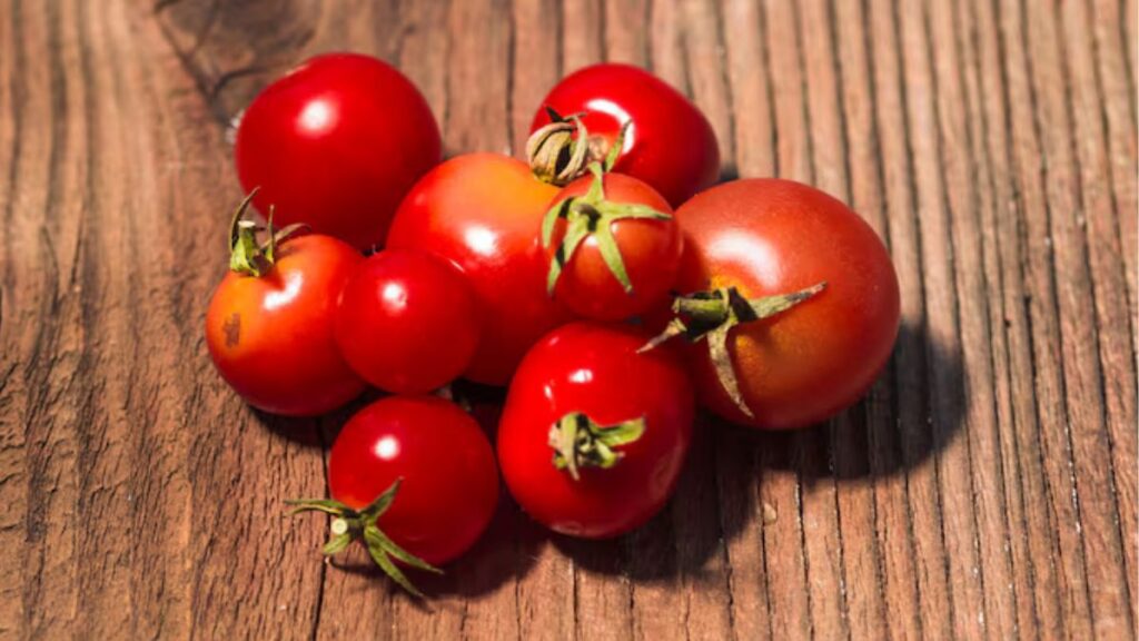 cacho de tomates-cerejas sob um mesa de madeira
