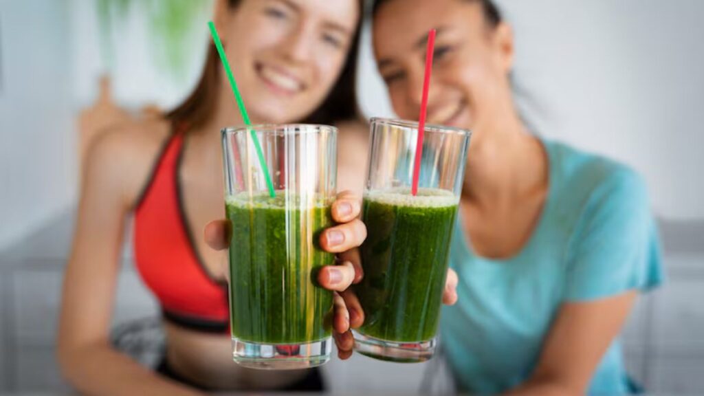 Mulheres segurando copos de suco verde