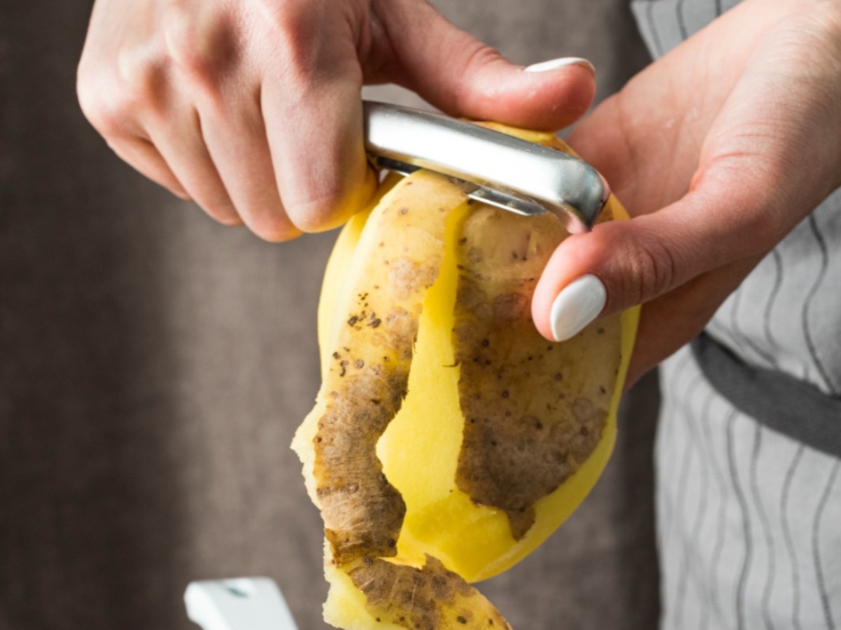 Imagem colorida de batata sendo descascada