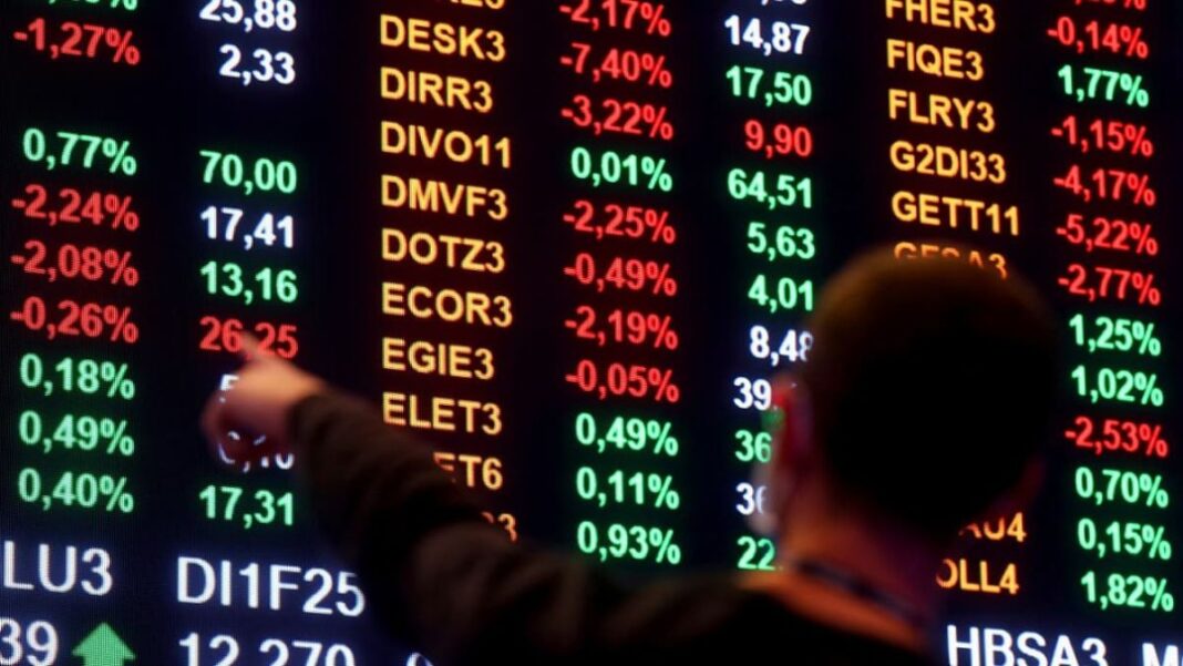 Ibovespa Homem aponta para números em painel da bolsa de valores