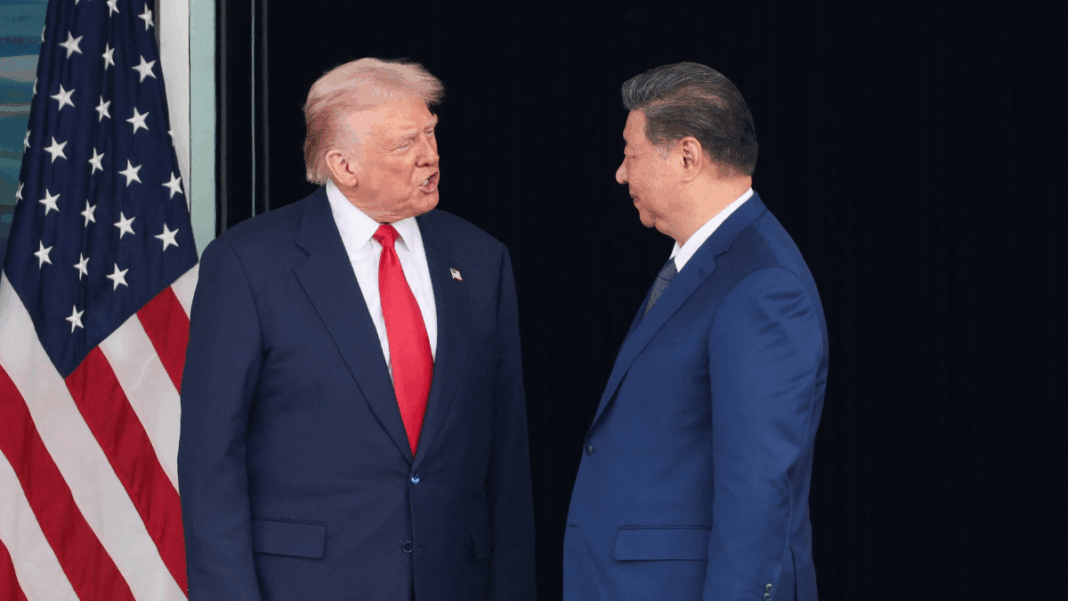 Trump Donald Trump e Xi Jinping se olham ao lado da bandeira dos EUA