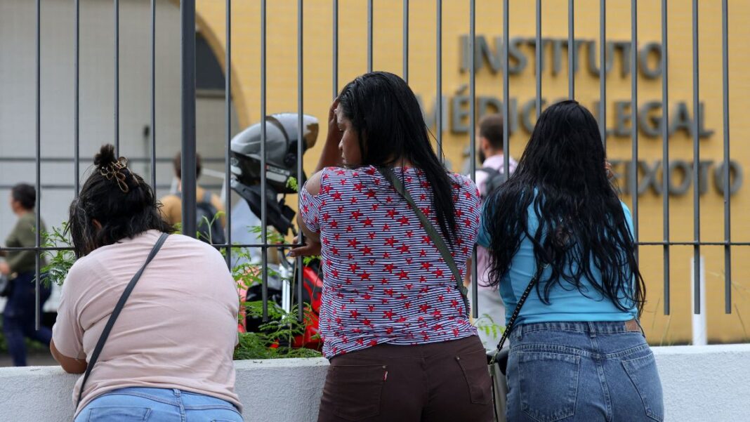 MP Mulheres aguardam diante do portão do Instituto Médico Legal