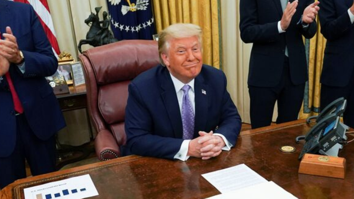 Donald Trump Donald Trump sentado à sua mesa na Casa Branca e sorrindo