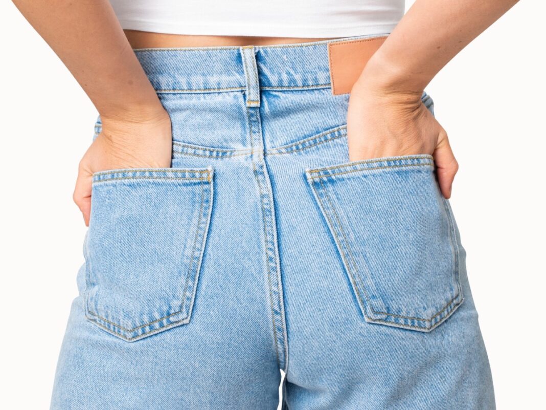 calca-jeans Mulher de costas vestindo calça jeans com as mãos no bolso