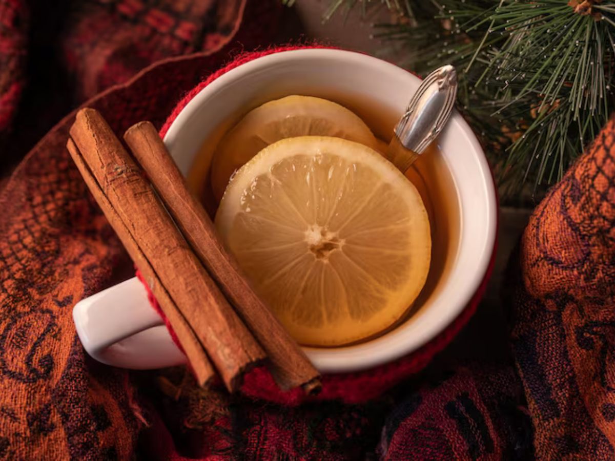 chas-que-podem-ajudar-regular-ciclo-menstrual Xícara com chá de canela com rodelas de limão