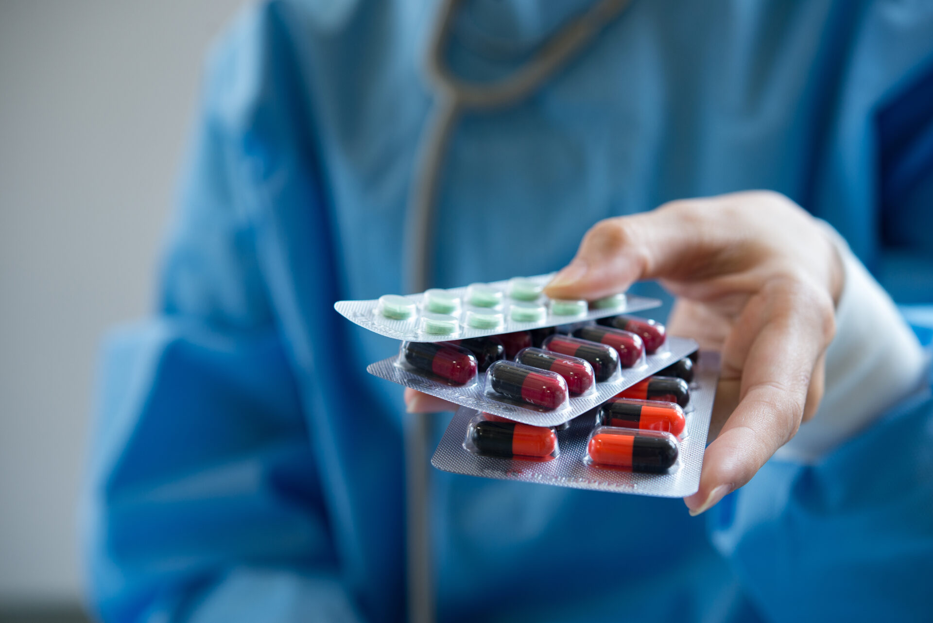 Médica segurando cartelas de comprimidos.