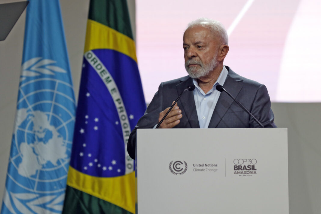 Lula fala em um púlpito, com bandeiras do Brasil e da ONU ao fundo, durante um evento oficial sobre clima.