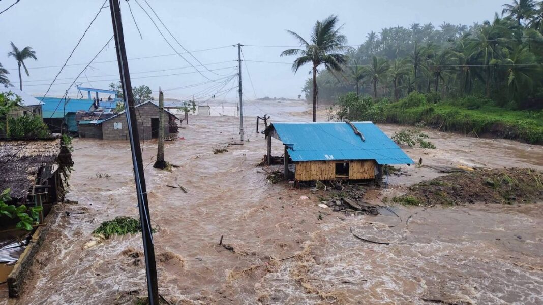 Cidade completamenta alagada nas Filiinas. Casa de madeira com água quase até o telhado, em meio de toda a água.