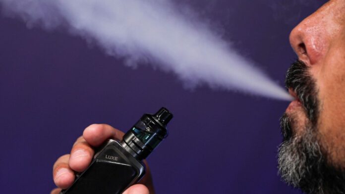 Homem barbudo fumando vape