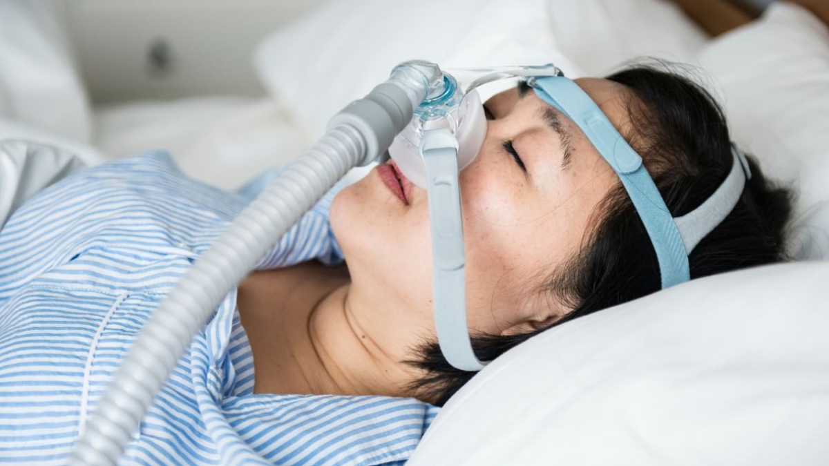 Mulher com um aparelho que auxilia na respiração durante o sono